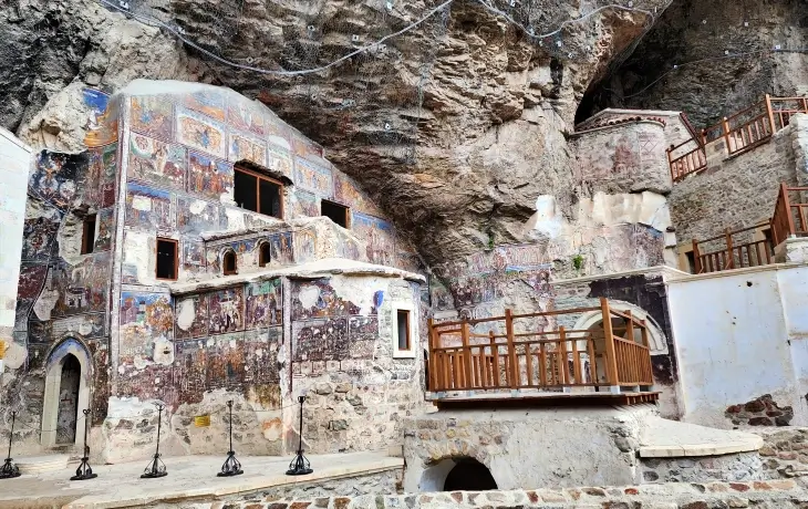 Sümela Manastırı’nın Ana Kaya Kilisesi ve çevresindeki fresklerle kaplı dış cephe. Kayalığın altına oyulmuş bölümlerde İncil sahneleri ve Komnenos dönemine ait resimler görülüyor.